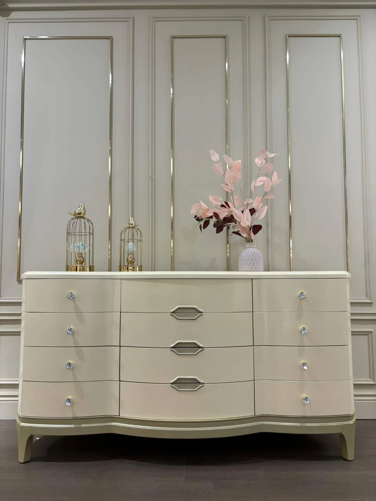 Cream-colored dresser with drawers and decorative knobs